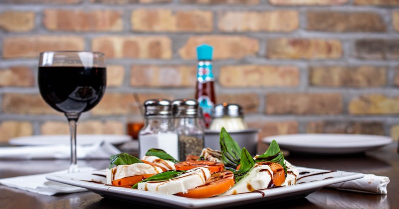 Caprese salad served with a glass of  red wine