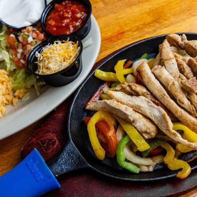 Chicken fajitas served with rice, cheese, pico de gallo, salsa, and sour cream.