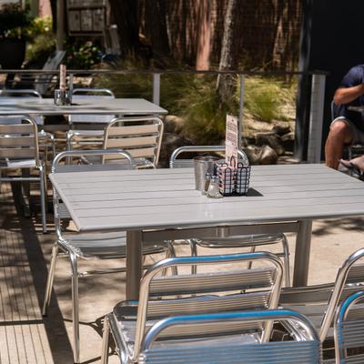 Close up of an outdoor seating area on a sunny day, tables and chairs.