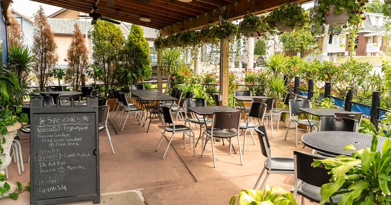Covered patio, seating area surrounded by a lot of plants
