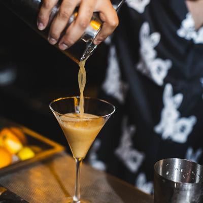 Bartender pouring a cocktail.