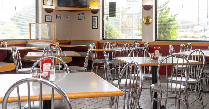 Interior - metal chairs and tables, condiments on the tables; large windows.