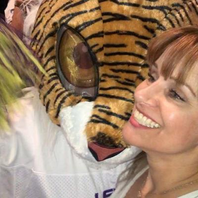 A girl hugging a tiger mascot