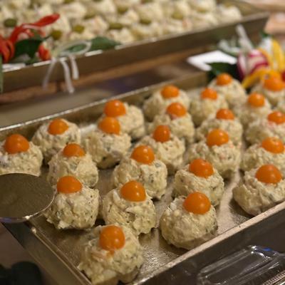 Appetizer scoops topped with cherry tomatoes on a serving tray.
