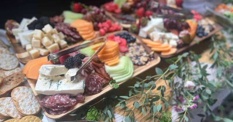 Charcuterie grazing table with various cheeses, meats, fruits and crackers