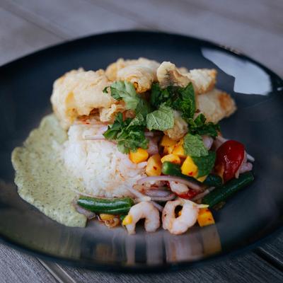 Fried perch on top of rice, with shrimp, salsa, and a creamy green sauce.