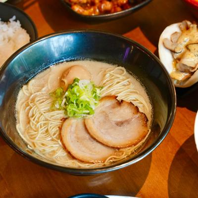 Bowl of Pork Broth Ramen with braised pork, green onions and soft boiled egg.