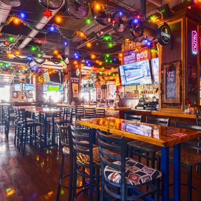 Interior with high tables, stools, various decorations and festive holiday lights.