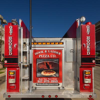 Hook and Ladder Pizza Co fire truck with a wood fired pizza oven advertisement and contact info.