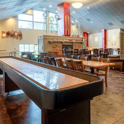 Long shuffleboard table in a lodge-style dining room.