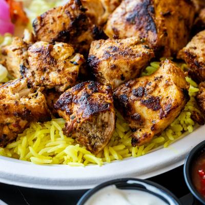 Grilled chicken kebab on a bed of saffron rice.