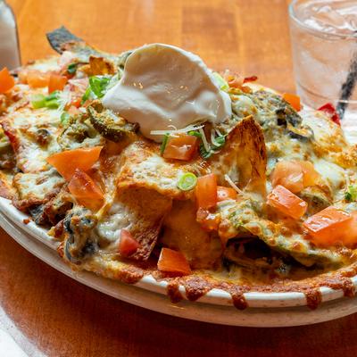Nachos with cheese sauce, mozzarella, olives, jalapenos, tomatoes, and scallions.