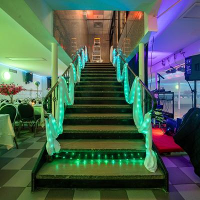 Interior, a staircase and banquet room decorated for a wedding party.