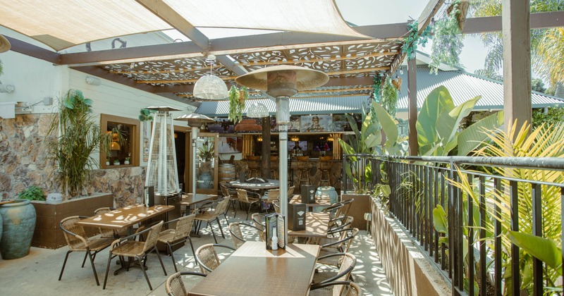 Patio with tables and wicker chairs under a canopy