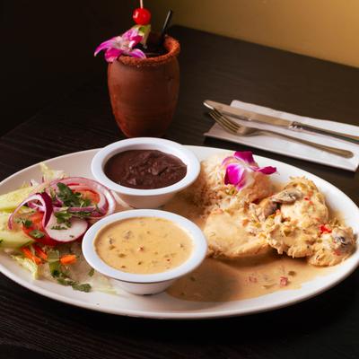 Chicken cooked in cream sauce, Served with rice, beans, and a small salad.