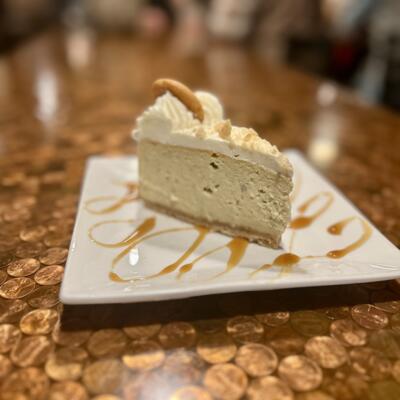 Slice of caramel cheesecake served on a rectangular white plate.