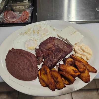 Grilled steak plate with eggs, refried beans, cheese and plantains.