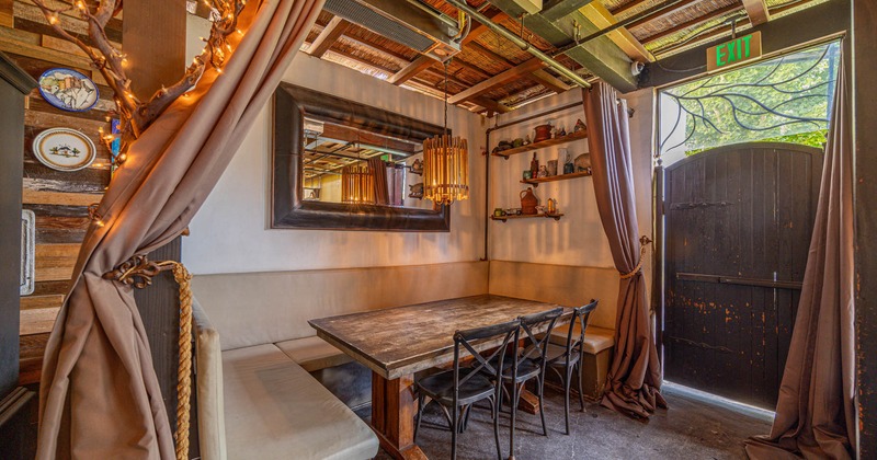 Cozy restaurant corner with a wooden table, chairs, bench, and rustic decor