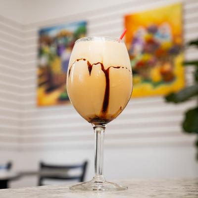 Creamy iced drink drizzled with chocolate and served in a stemmed glass.