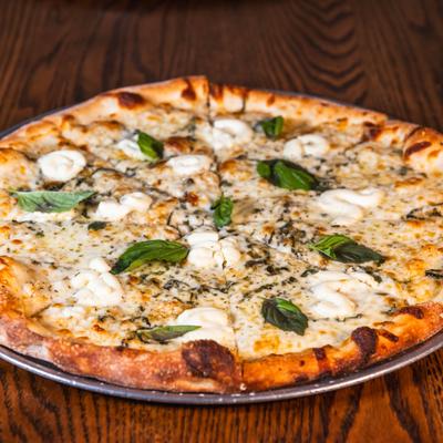 Pizza Bianca sits on a wooden table.