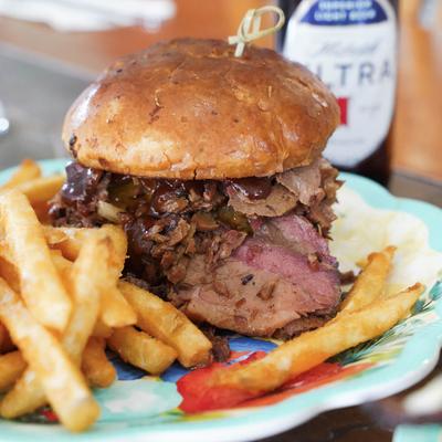 Smoked Brisket Sandwich served with fries and a beer.