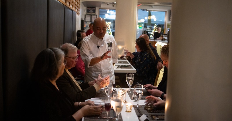 Cheff talkig to guests at the table
