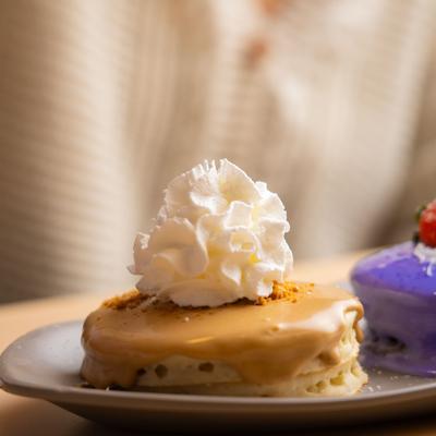 Malasada pancake topped with whipped cream.