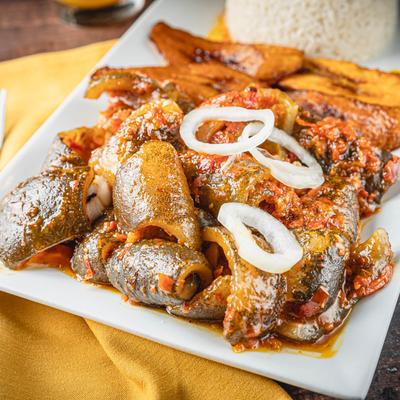 Cow skin dish with a side of rice and plantains.