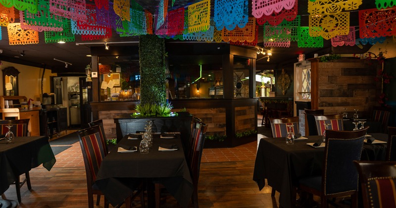 Lively Mexican-style interior, spacious dining area decorated with hanging paper ornaments