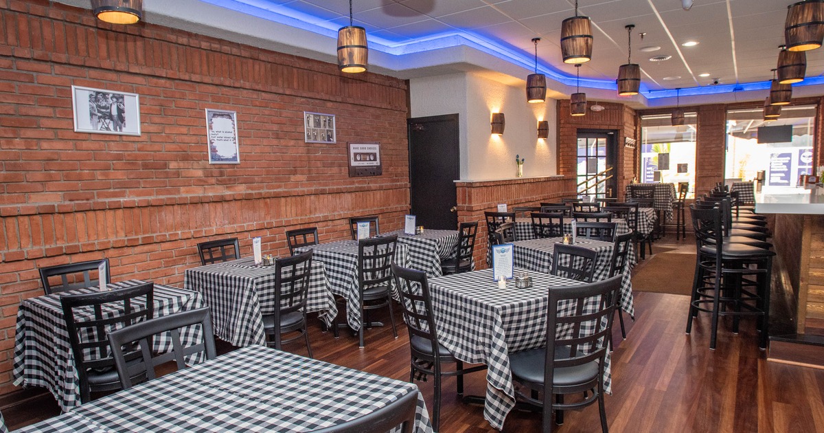 Interior of a restaurant with checkered tables, black wooden chairs