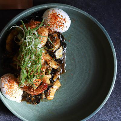 Squid ink noodles with seafood and poached eggs.