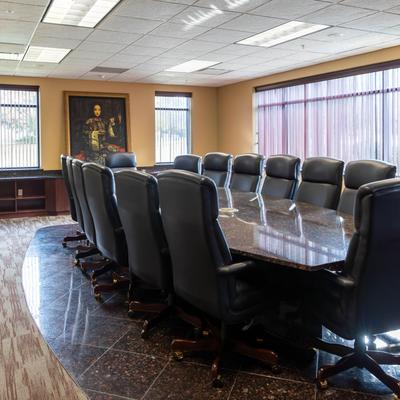 A board meeting table and arm chairs.