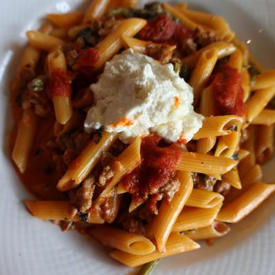Penne pasta, with crumbled sausage, tomato sauce, and ricotta cheese.