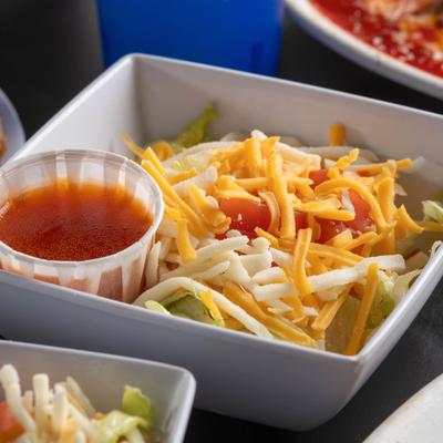 Salad with lettuce, tomato, shredded cheese, and dressing.