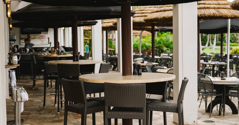 Outdoor restaurant patio with black umbrellas and stone flooring