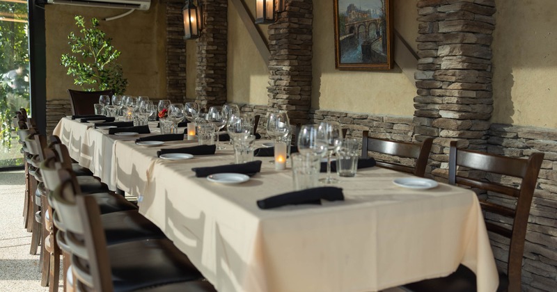 Interior, dining room with stone columns, lanterns, and long tables set with plates
