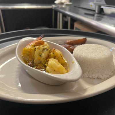 Shrimp, cooked in garlic butter, with white rice, black beans, and fried plantains.
