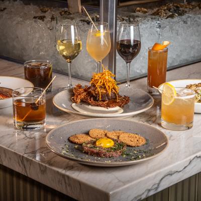 A selection of dishes and drinks arranged at the corner of the food bar, a cool seafood display case behind
