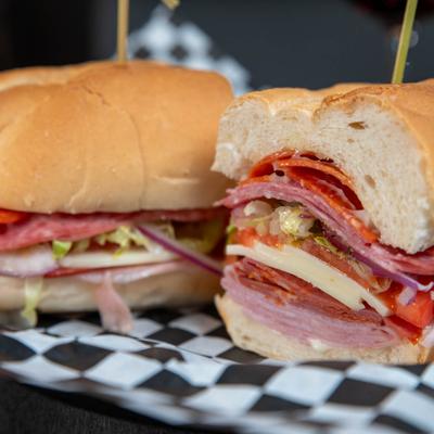 Sandwich with cold cuts, provolone, lettuce, tomato, onion, seasoning, and mayo.