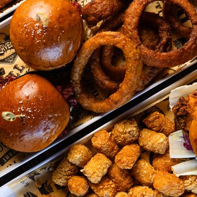 Sliders with onion rings and tater tots.