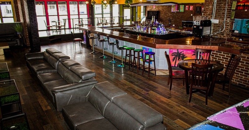 Interior, bar area with bar stools, tables, chairs and sofas