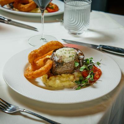 Steak served with mashed potatoes and onion rings.