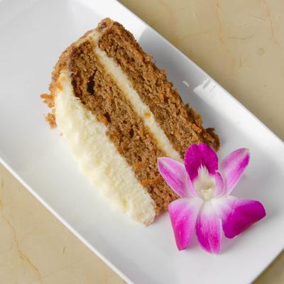 Carrot cake plate with purple flower garnish.