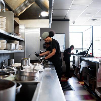 Kitchen interior with kitchen staff preparing food.