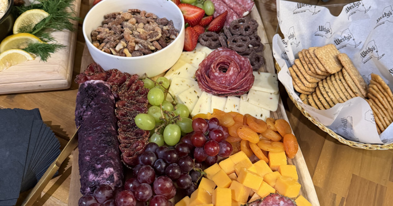 Charcuterie board filled with a variety of meats, cheeses, fruits, and snacks