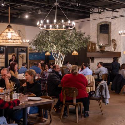 Crowd of people sitting in dining area at dinnertime.