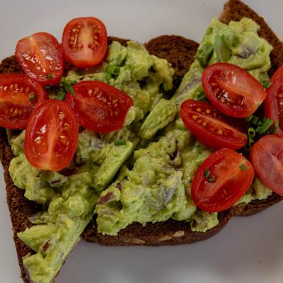 Avocado toast with cherry tomatoes, top view.