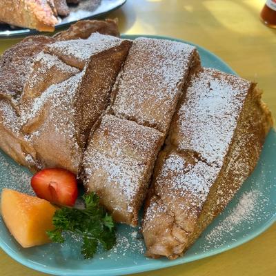 French toast slices with powdered sugar and fruit garnish.