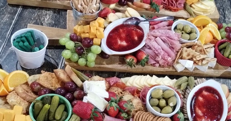 Charcuterie boards with a variety of meats, cheeses, fruits and crackers