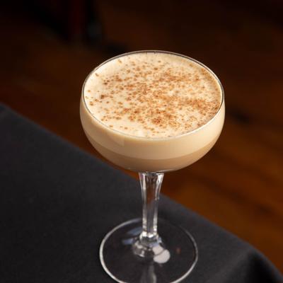 A glass of Tiramisu Martini sits on a dark tablecloth.